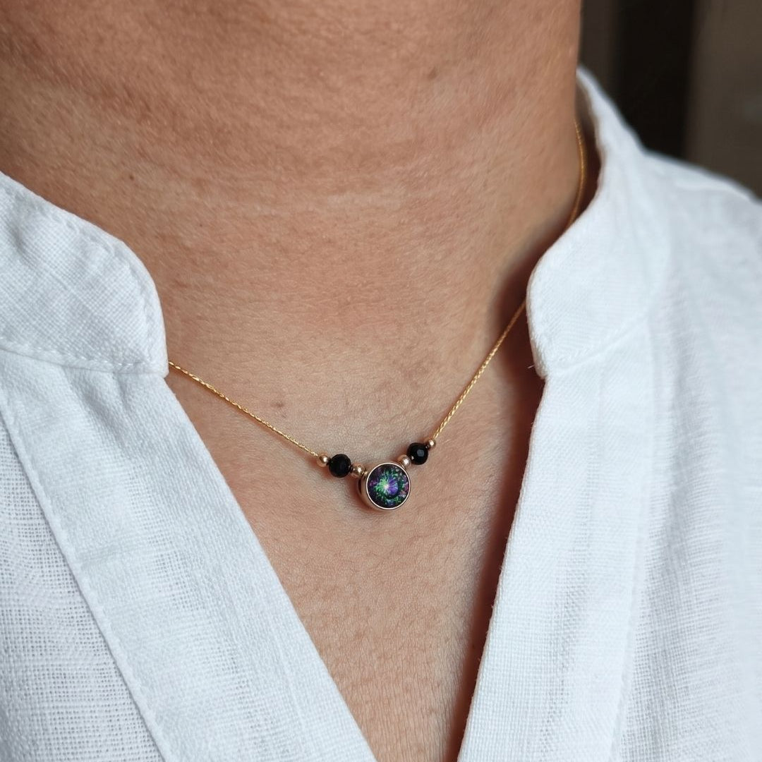 Necklace with a pendant worn by a person in a white shirt
