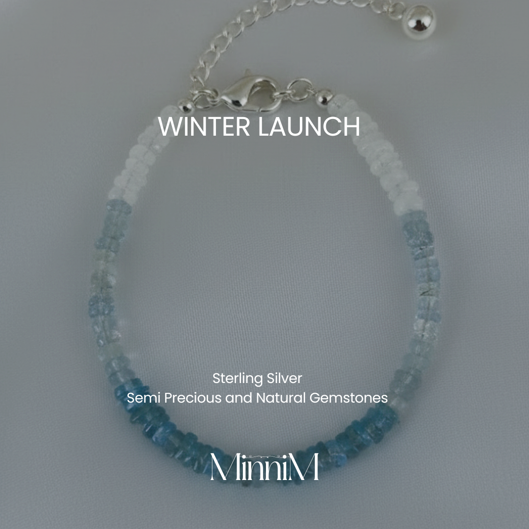 Blue beaded bracelet with silver chain on a gray background, featuring 'MinniM' brand.