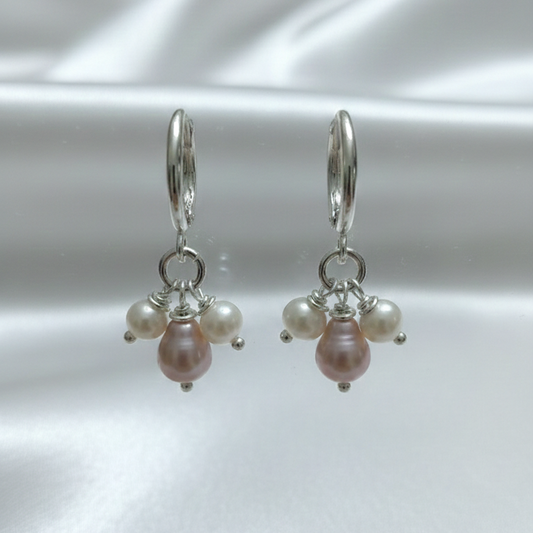 Pair of pearl earrings on a white satin background