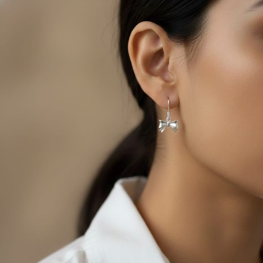 wearing a silver bow-shaped earring 
