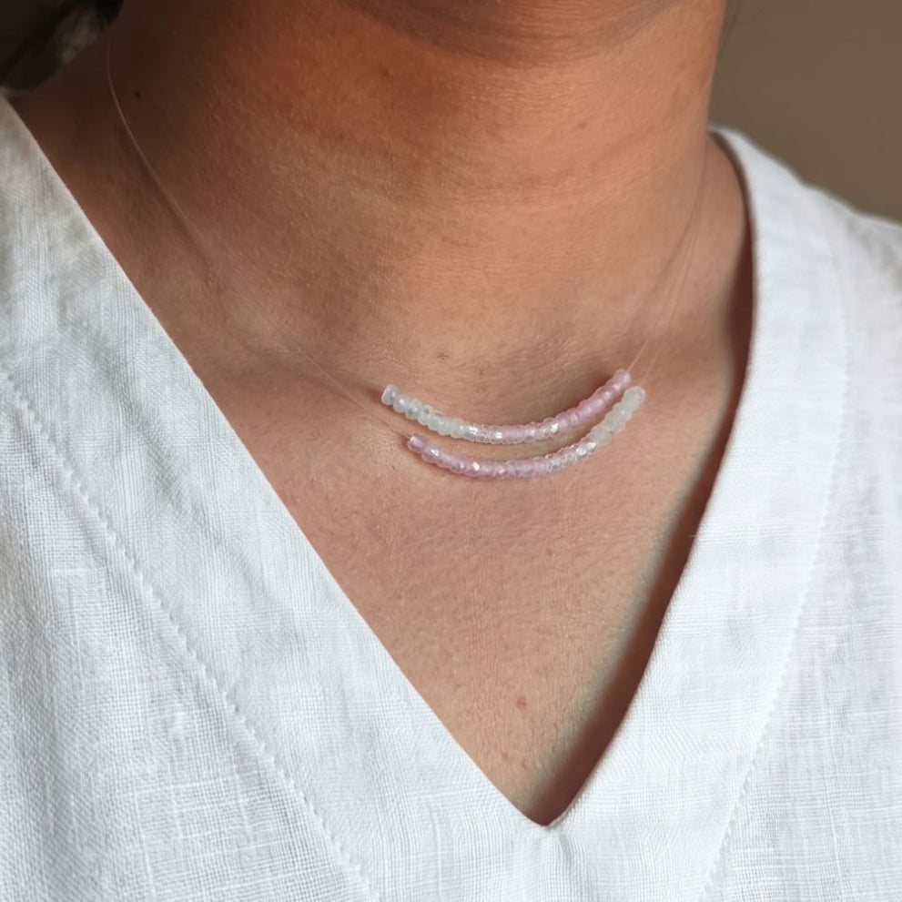 Person wearing a delicate necklace with a white shirt